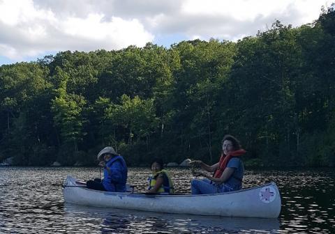 Three people paddling a canoe