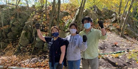 Three volunteers with masks on raising their fists